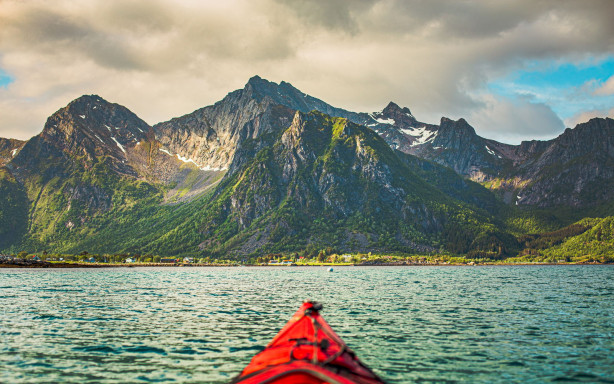 Kayaking on calm water with dramatic mountain scenery in Lofoten