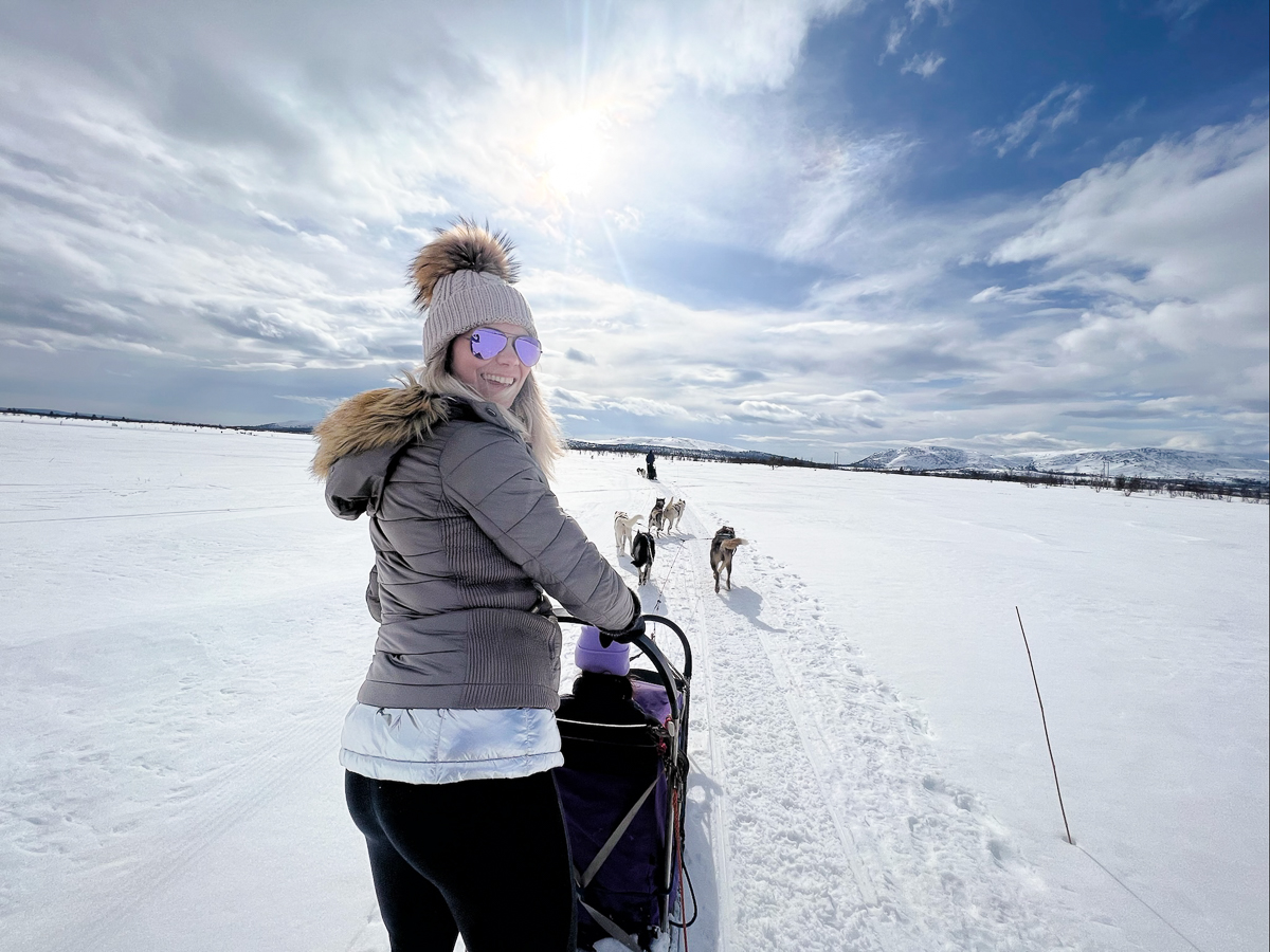 Woman cross-country skiing in snowy landscape under a cloudy sky