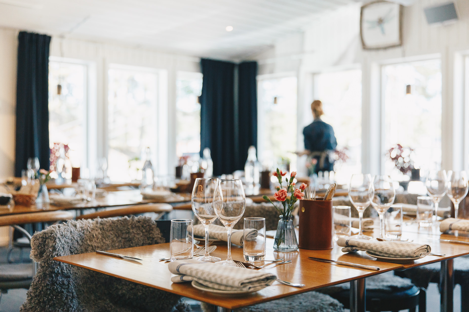 Set dining table indoors with glassware, candles and winter decor, in a bright event room
