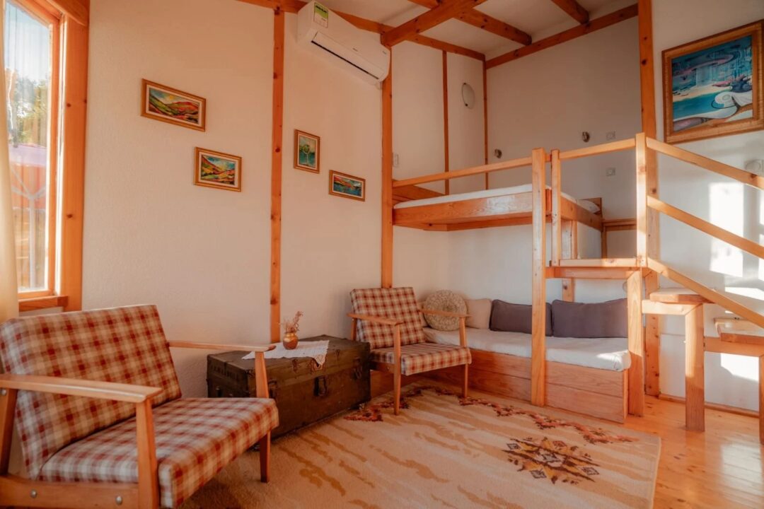 Rustic cabin lounge with wooden frame bunk beds and patterned seating