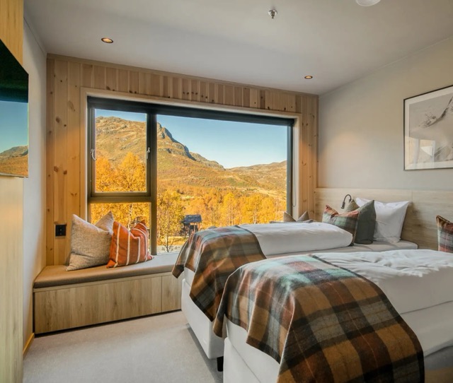 Cozy bedroom with wooden window and clear mountain view.