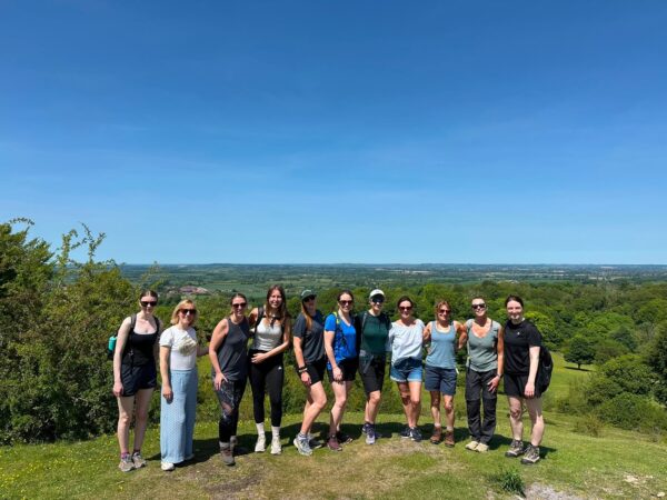 Women hikers posing on a scenic hilltop viewpoint during an outdoor walking trip