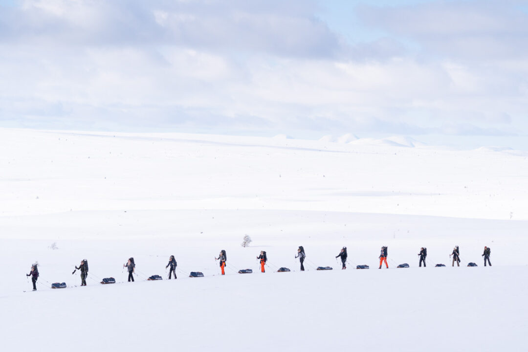 Women snow trekking across a snowy landscape on a winter hike