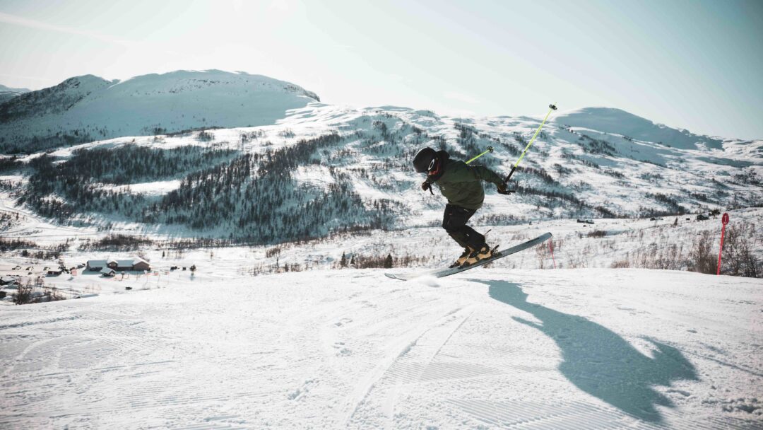Skier carving a turn on a snowy piste in the mountains