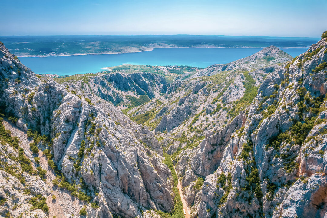 Rocky mountain ridgeline overlooking a coastal bay and sea in Europe