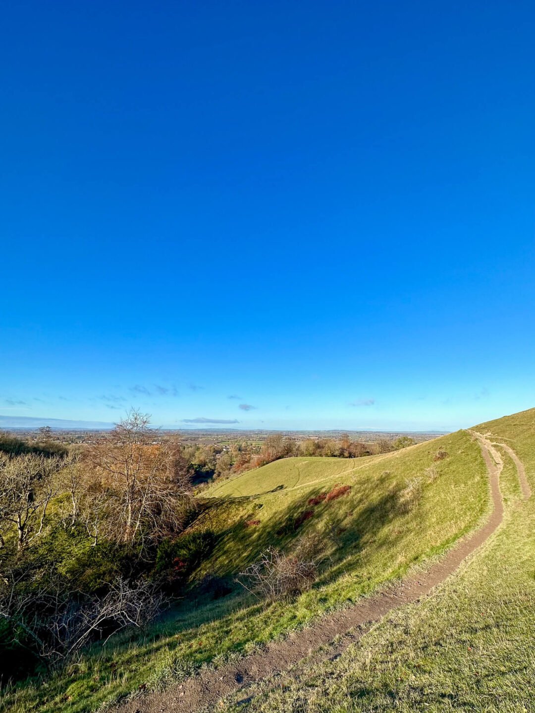Winding footpath across grassy hills in the Chilterns under a clear blue sky