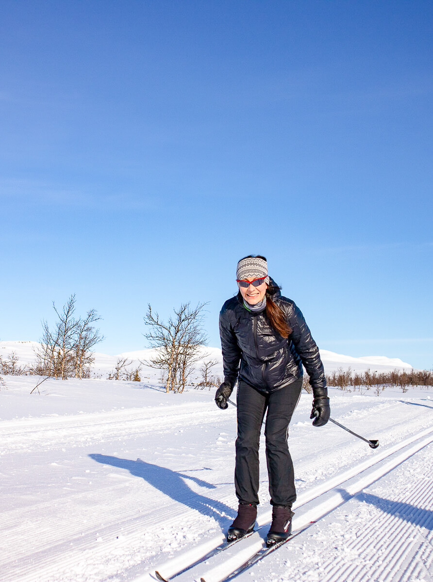 Woman cross skiing in snowy landscape.