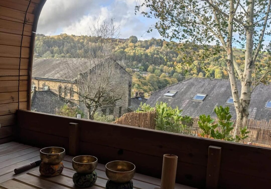 Sauna terrace with steaming cups overlooking countryside village and hills in the UK
