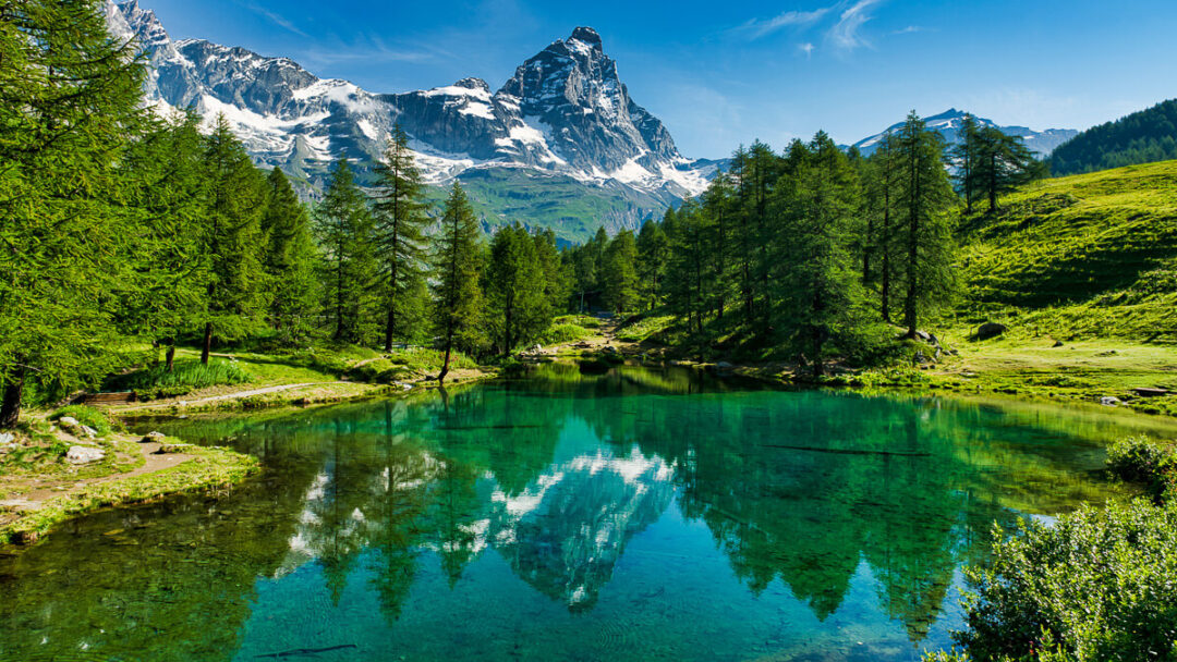 Serene lake reflecting majestic mountains in Italy