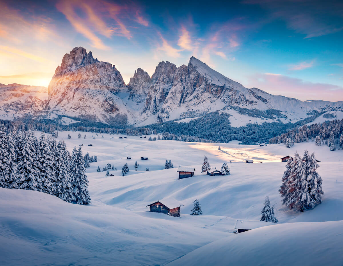 Snowy mountains under a colourful sky in Italy