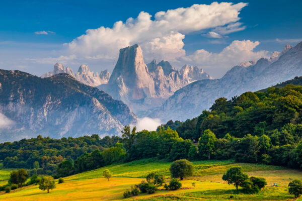 Mountain range landscape in Spain with green valleys and clouds over the peaks