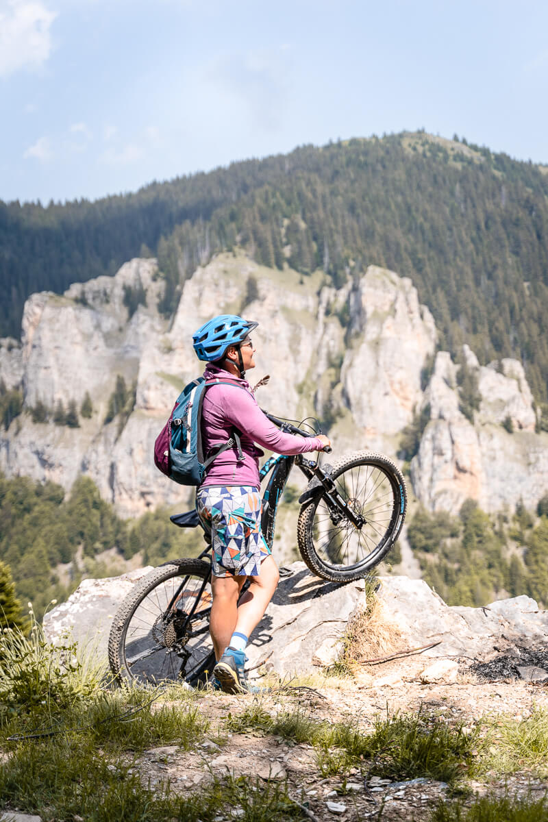 Woman mountain biking outdoors with backpack in rocky Alps landscape