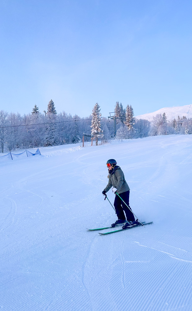 Woman skiing down a snow-covered slope in winter mountains