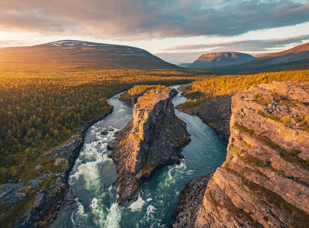 River winding through a canyon with forests and distant mountain peaks at golden hour in the UK