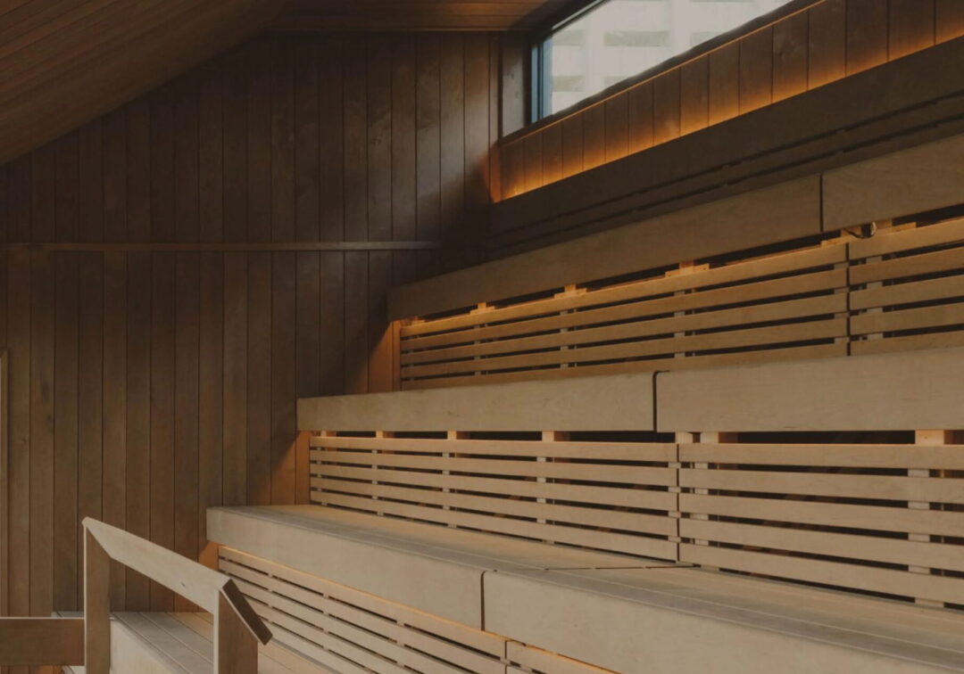Wooden sauna interior with slatted benches and warm lighting in the UK