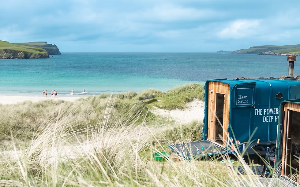 Outdoor sea-side sauna in coastal dunes with sign text “True Power” and “DEEP HEAT”