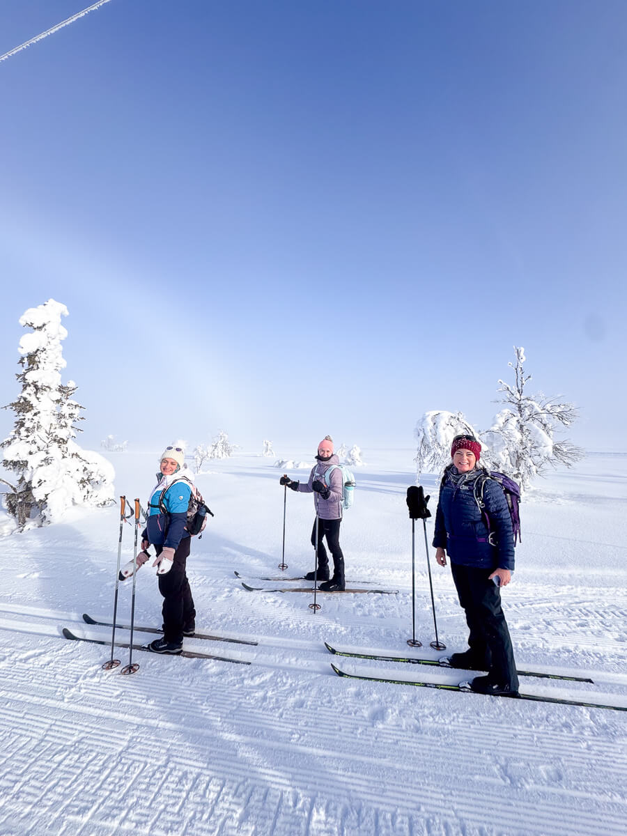 Women cross-country skiing across snowy Finland, with skis and poles on a frosty track