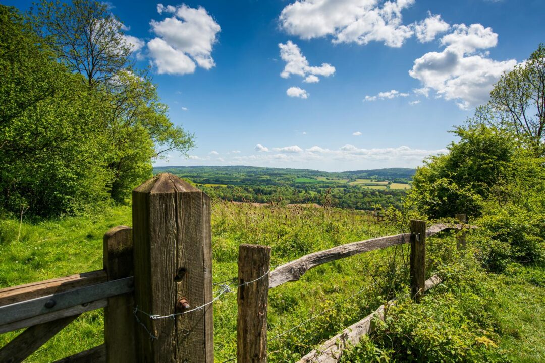 Hiking viewpoint from a wooden fence over green countryside hills near London