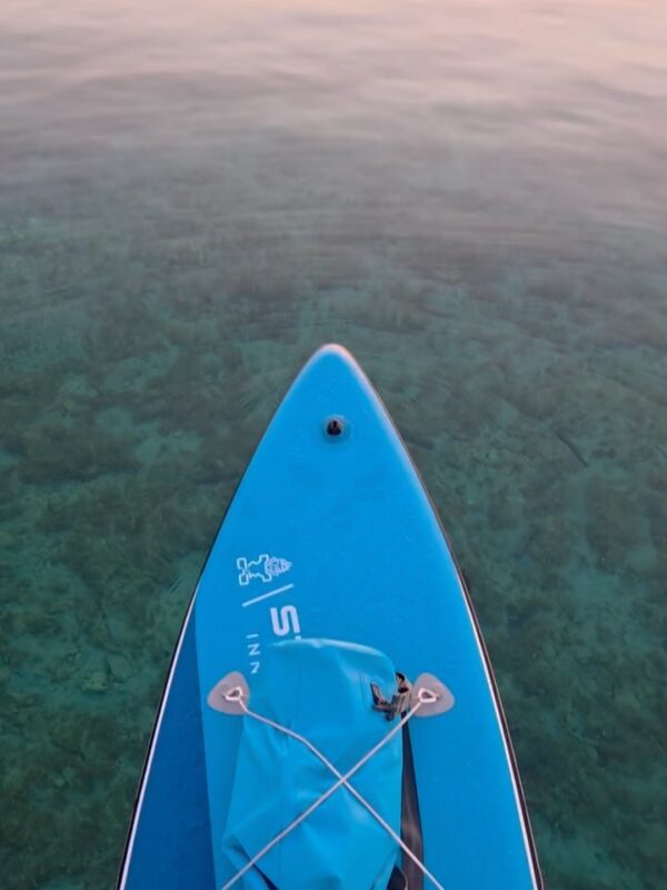 Blue paddleboard (SUP) in clear Adriatic Sea water near Zadar archipelago, Croatia.