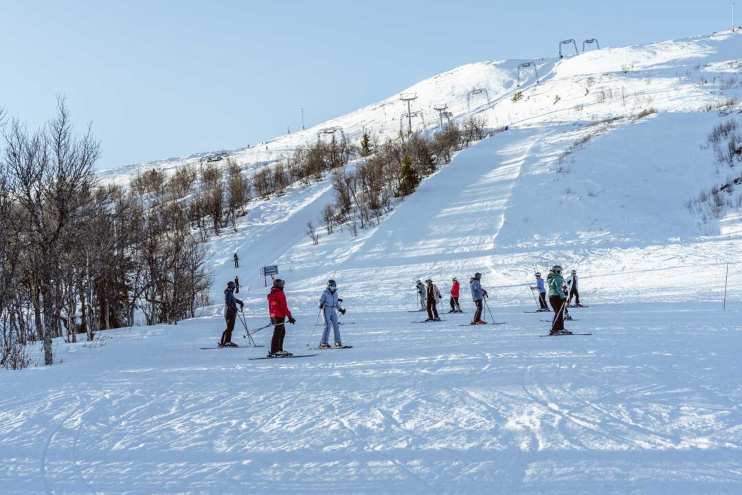 Skiers on a snowy piste with chairlift in a winter resort