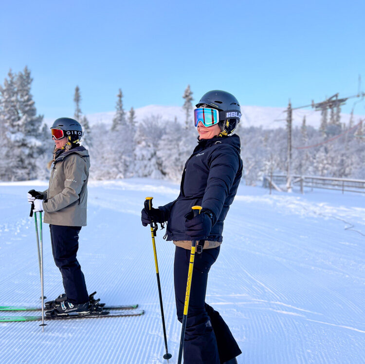 Women on skis with poles at a snow piste in Sweden, training for ski holiday